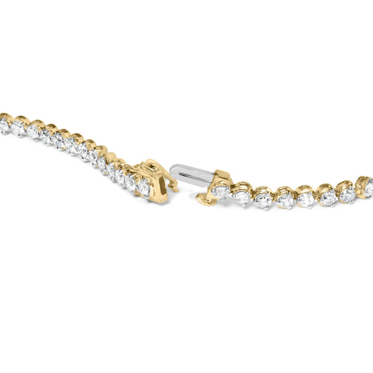 Close-up angled view of a yellow metal bracelet adorned with two rows of white round gemstones in prong settings, shown open on a white background.