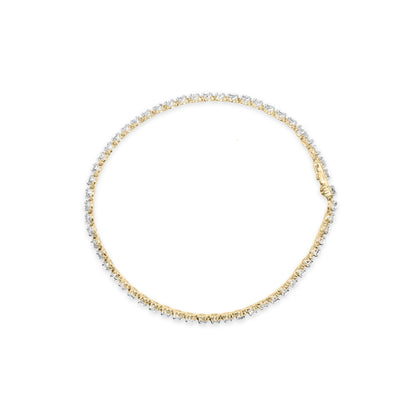 Close-up top view of a yellow metal bracelet featuring round white gemstones in prong settings along its length.
