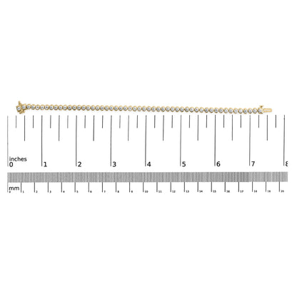 Straight yellow metal bracelet with round white gemstones in prong settings, laid flat on a ruler for size reference, top-down angle.