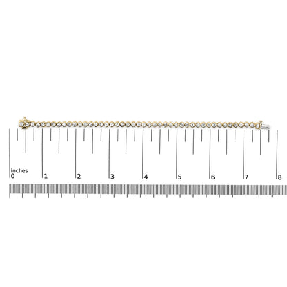Close-up front view of a yellow metal bracelet with round white gemstones in prong settings, shown on a ruler scale.
