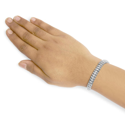 White metal bracelet with two rows of round white gemstones in prong settings, worn on model's wrist, shot from above.