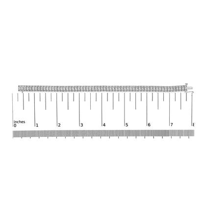 White metal bracelet with multiple rows of round white gemstones in prong settings, laid flat on a ruler for size reference, top-down view.