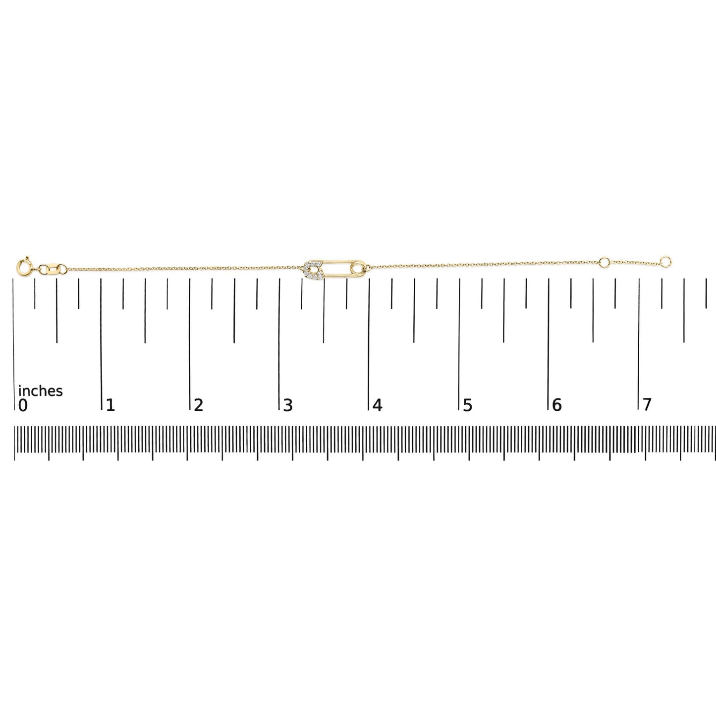 Yellow metal bracelet with a safety pin charm adorned with white round gemstones in prong settings, shown on a measuring scale from above.