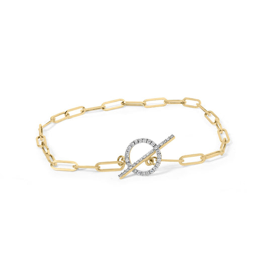 Yellow metal bracelet with elongated chain links featuring a circular toggle clasp adorned with white gemstones, photographed from an overhead angle.