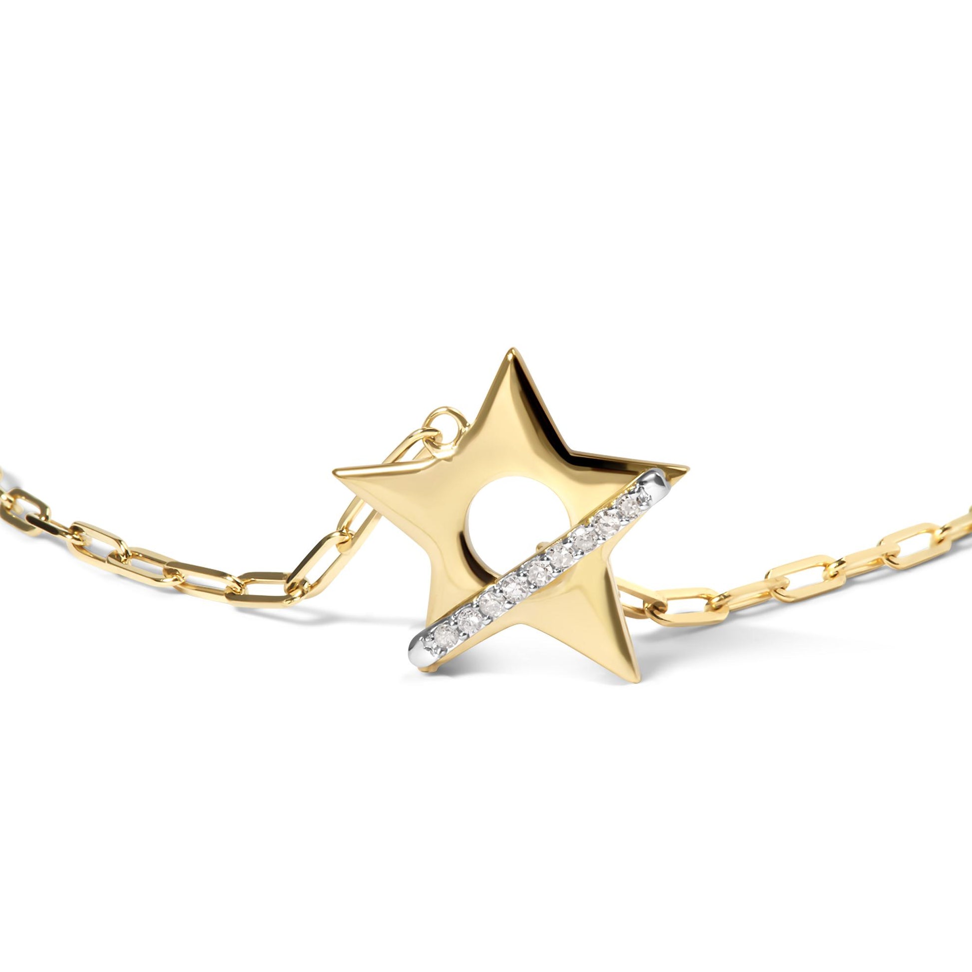 Close-up angled view of a yellow metal star-shaped bracelet charm with a diagonal bar set with round white gemstones, attached to a yellow metal chain.
