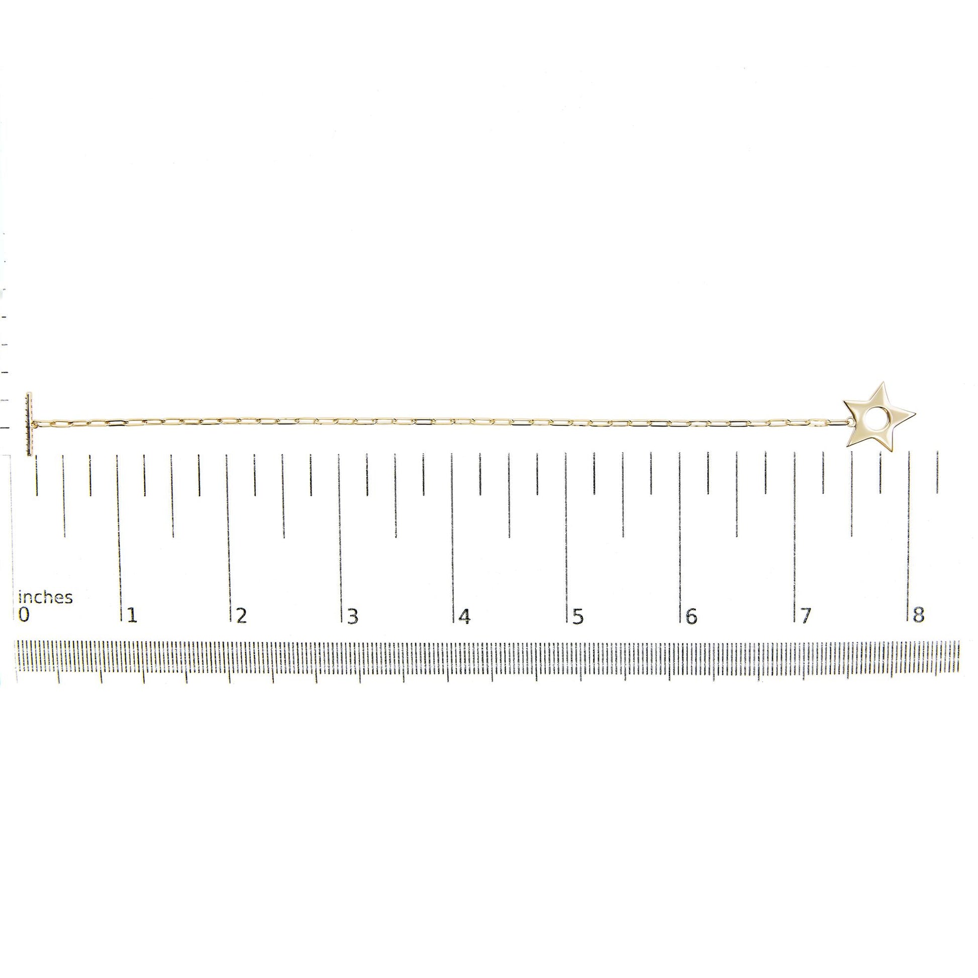 Yellow metal bracelet with a star-shaped charm, featuring round white gemstones in prong settings, shown on a scale from a top-down angle.