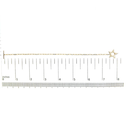 Yellow metal bracelet with a star-shaped charm, featuring round white gemstones in prong settings, shown on a scale from a top-down angle.
