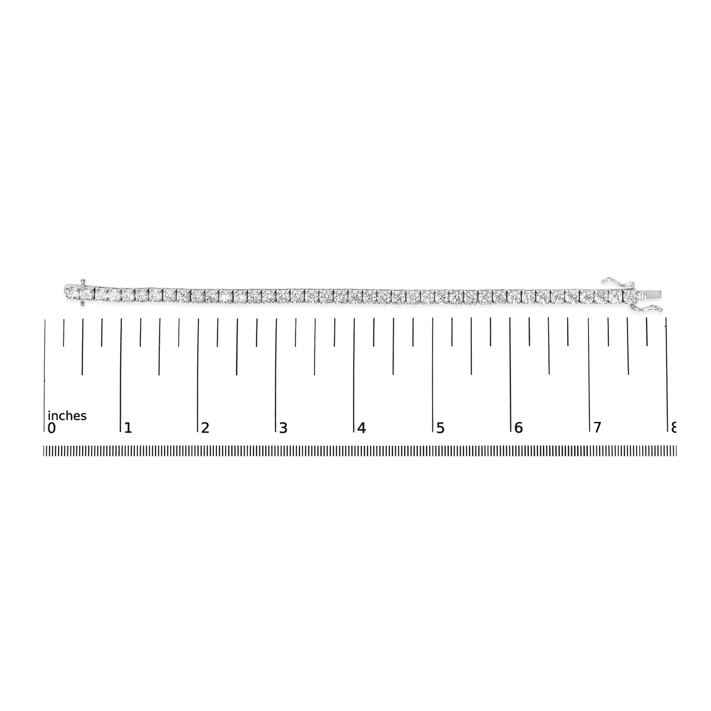 White metal bracelet with round white gemstones in 4-prong settings, laid flat on a ruler for size reference, top-down angle.