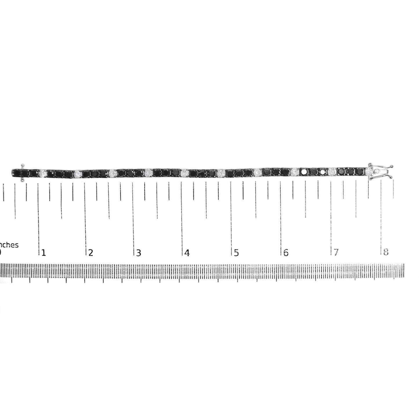 White metal bracelet with alternating black and white round gemstones in 4-prong settings, displayed flat on a ruler for size reference, shown from a top-down view.
