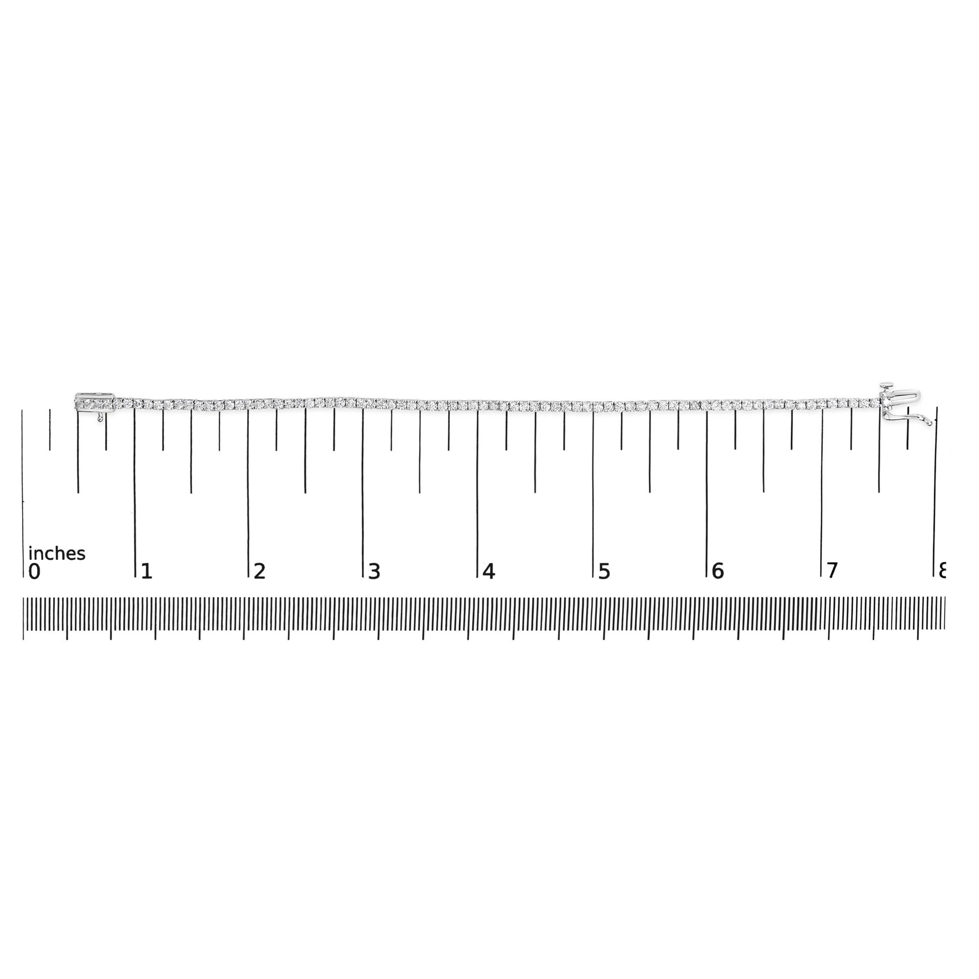 White metal tennis bracelet with round white gemstones in four-prong settings, laid flat on a ruler for size reference, top-down angle.