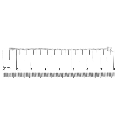 White metal tennis bracelet with round white gemstones in four-prong settings, laid flat on a ruler for size reference, top-down angle.