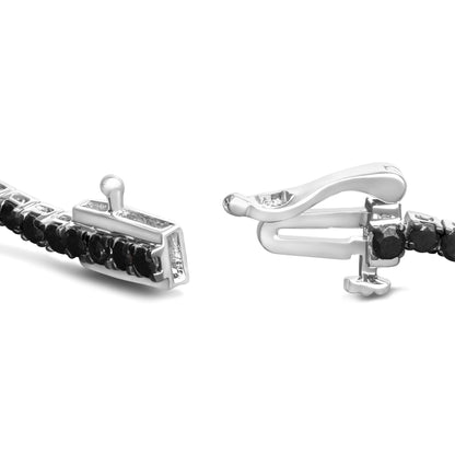 Close-up, angled view of a white metal bracelet featuring round black gemstones in prong settings along the band and a detailed clasp.