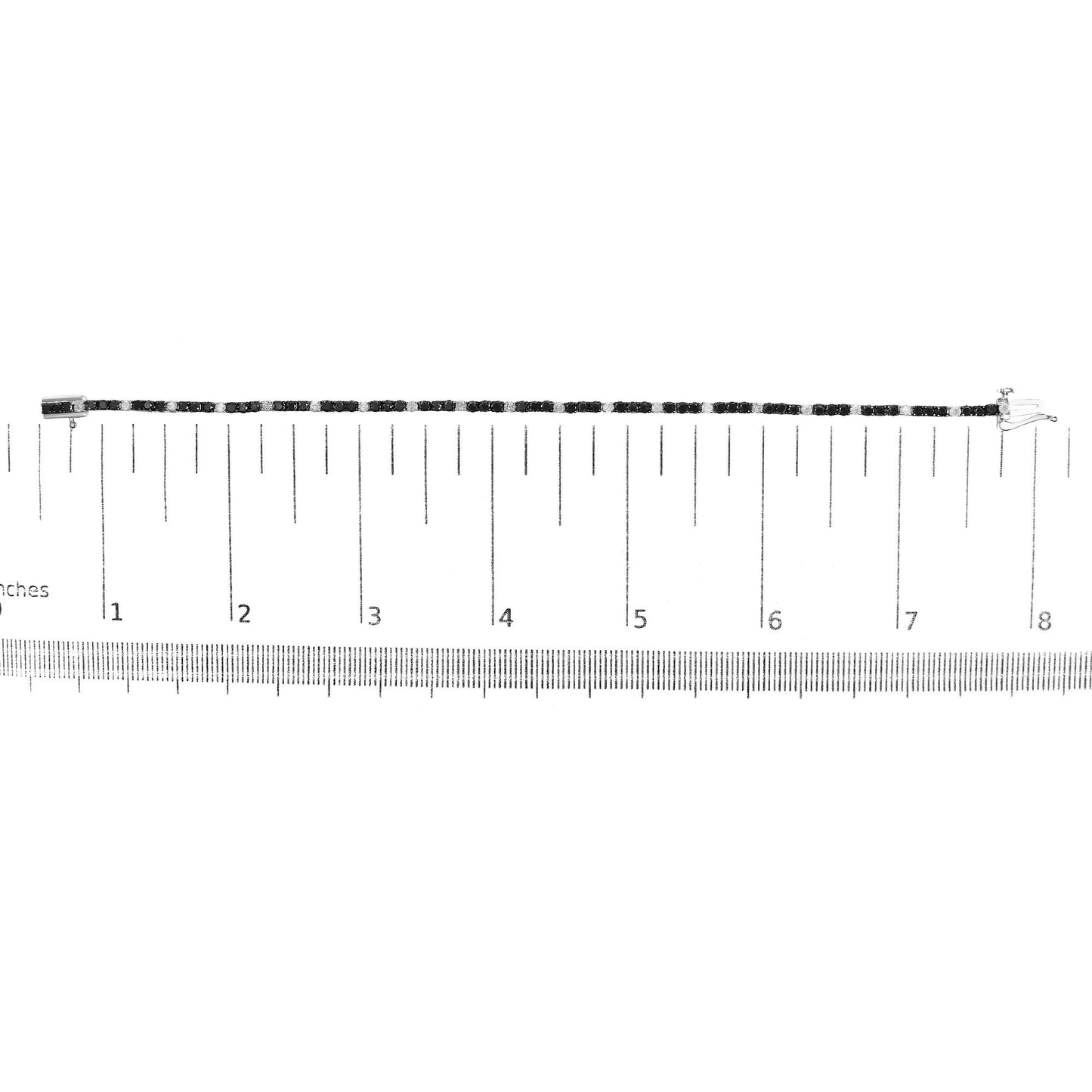 White metal bracelet with alternating round black and white gemstones in 4-prong settings, displayed flat on a ruler for size reference, top-down view.