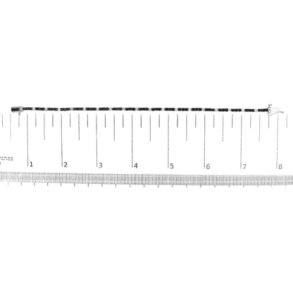 White metal bracelet with alternating round black and white gemstones in 4-prong settings, displayed flat on a ruler for size reference, top-down view.