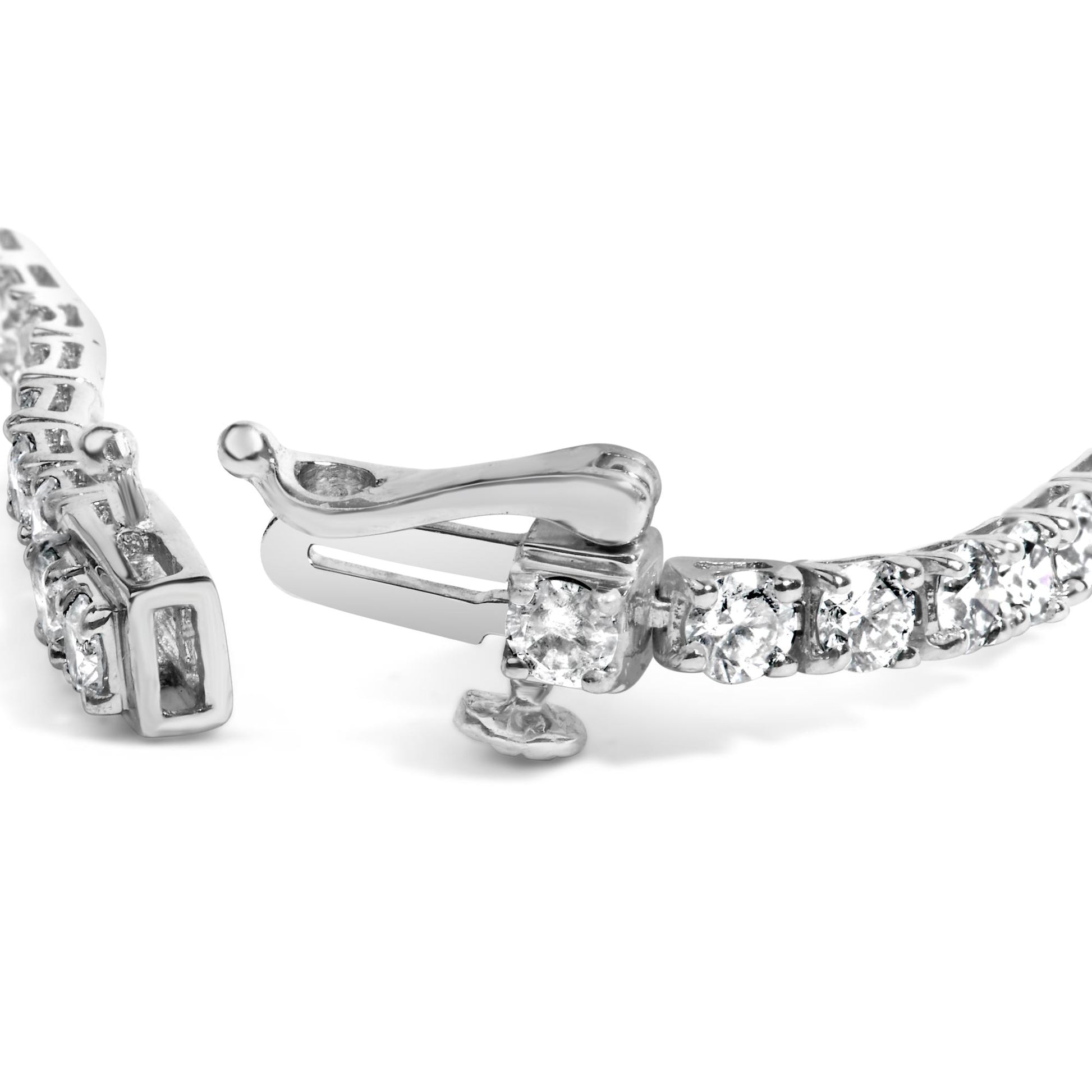 Close-up side angle of a white metal bracelet with round white gemstones in 4-prong settings, showing the clasp mechanism.