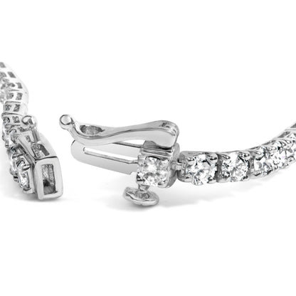Close-up side angle of a white metal bracelet with round white gemstones in 4-prong settings, showing the clasp mechanism.