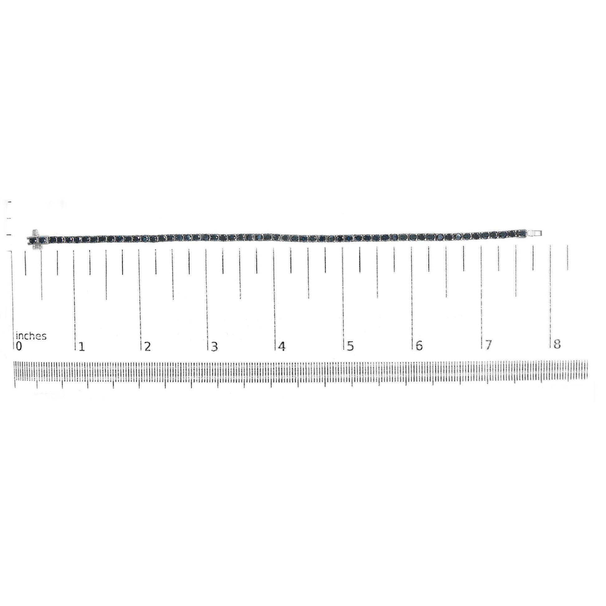 White metal bracelet with round black gemstones in prong setting, displayed flat on a ruler for size reference, top-down view.