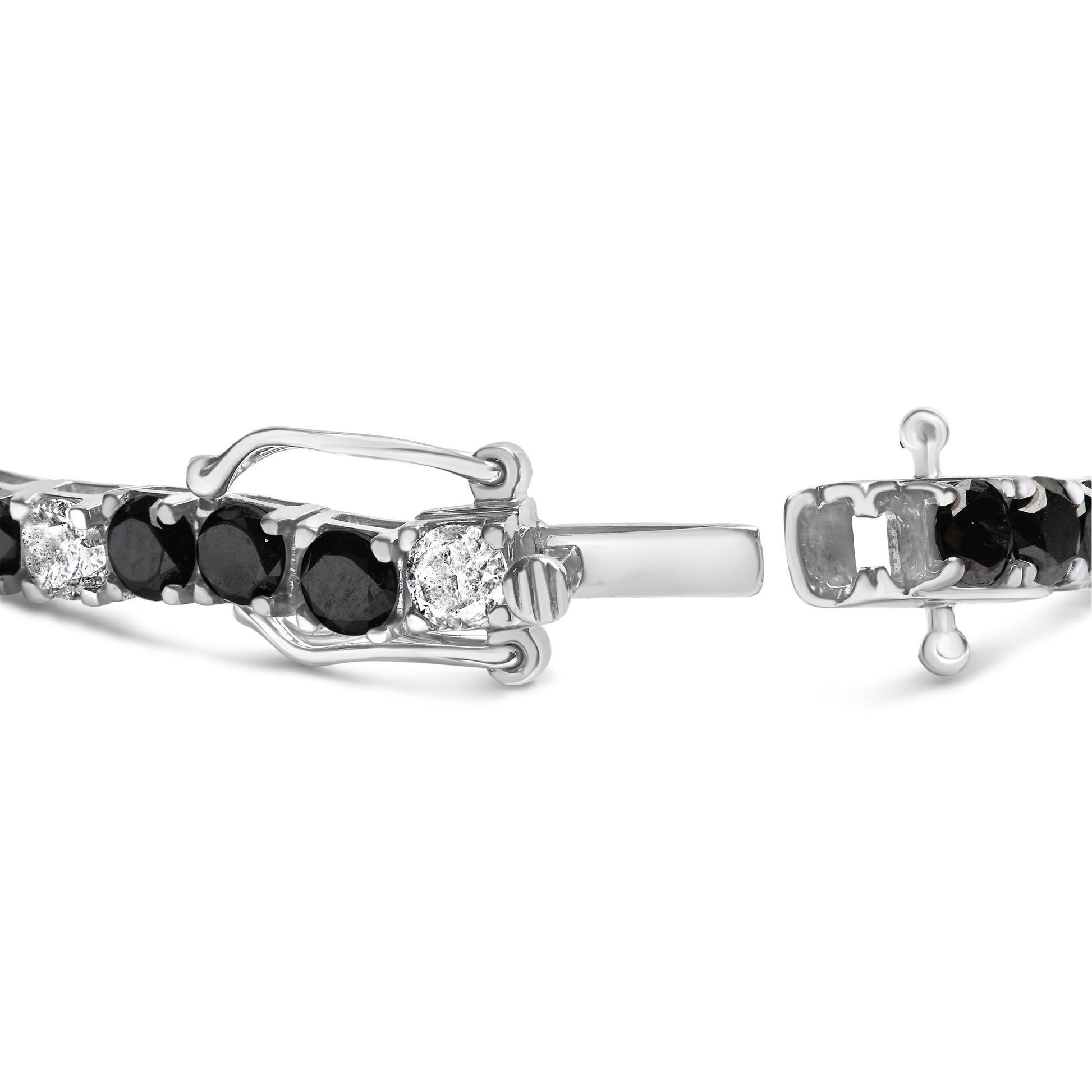Close-up front angle of a white metal bracelet with alternating round white and black gemstones in four-prong settings, showing the clasp details.