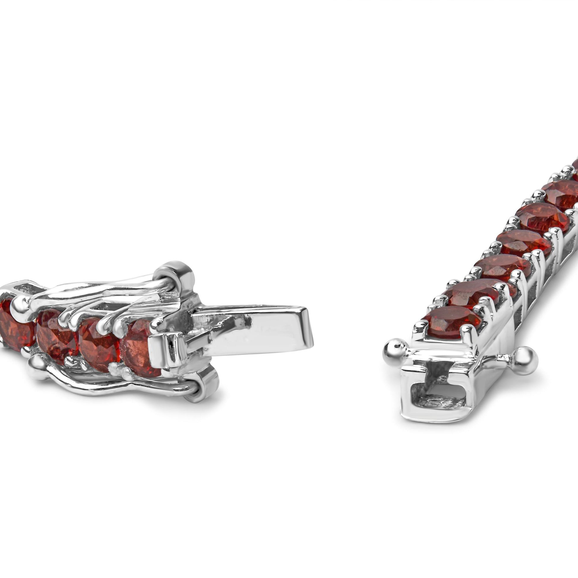 Close-up angle of a white metal bracelet with multiple round orange gemstones set in four-prong settings, showing the clasp mechanism.