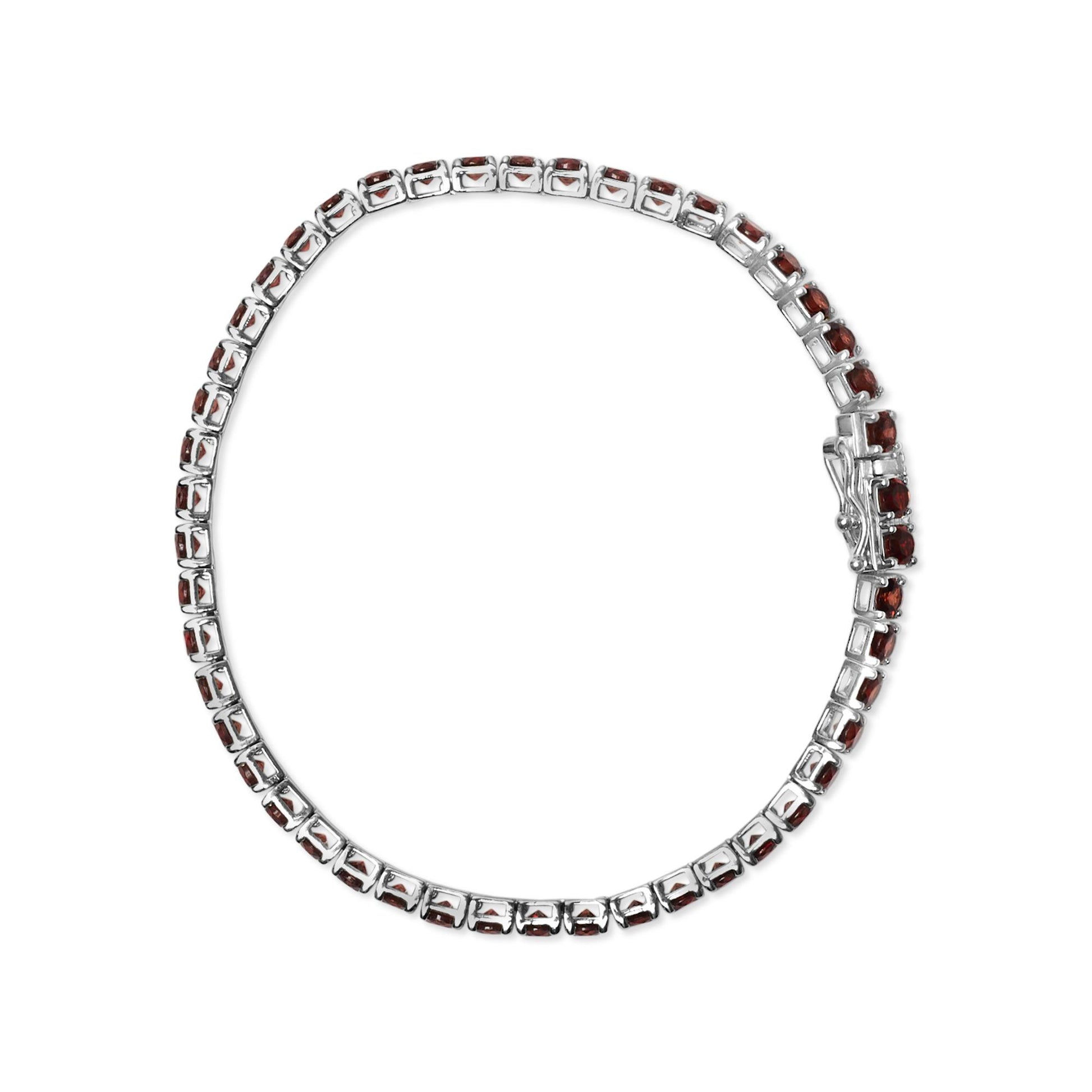 Top-down view of a white metal bracelet with round orange gemstones in 4-prong settings all around.