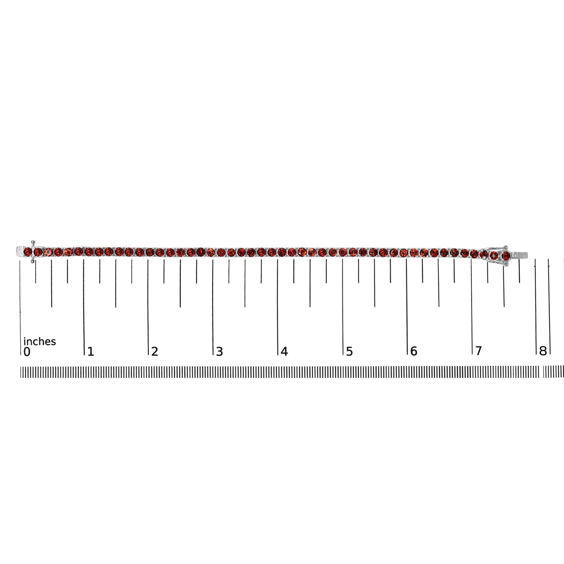 White metal bracelet with round orange gemstones in 4-prong settings, laid flat on a ruler for size reference, top-down angle.