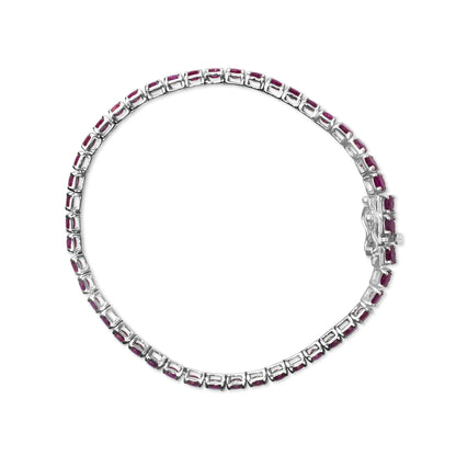 Top-down view of a white bracelet with pink round gemstones in four-prong settings arranged in a continuous line.