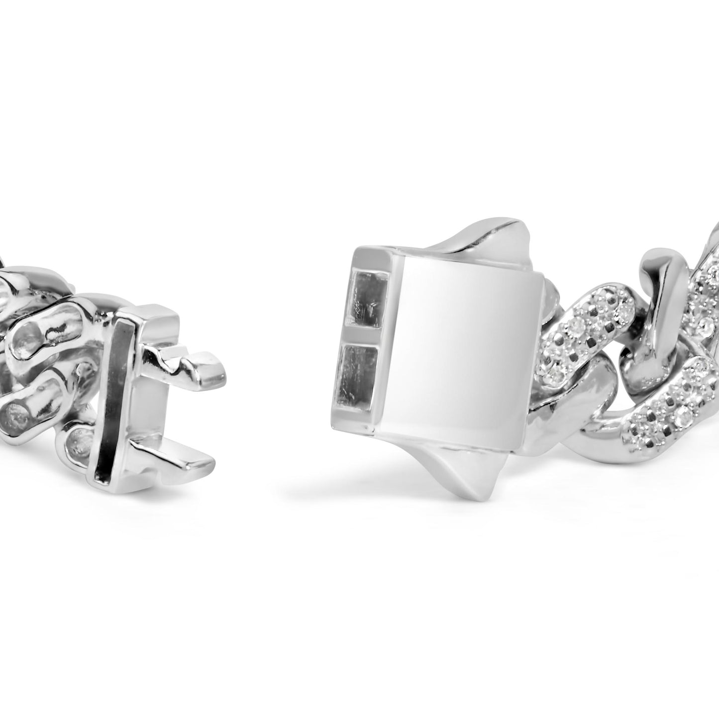 Close-up image of a white metal bracelet clasp and part of the chain featuring round white gemstones in prong settings, shot from a low angle on a white background.