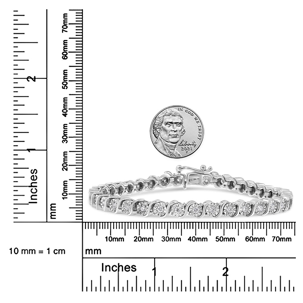 White bracelet with round white gemstones in a curved setting, shown from a side angle on a ruler and scale for size reference with a coin above it.