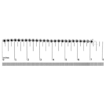 White metal bracelet with alternating round black gemstones in prong settings, shown flat on a measuring scale in a top-down view.