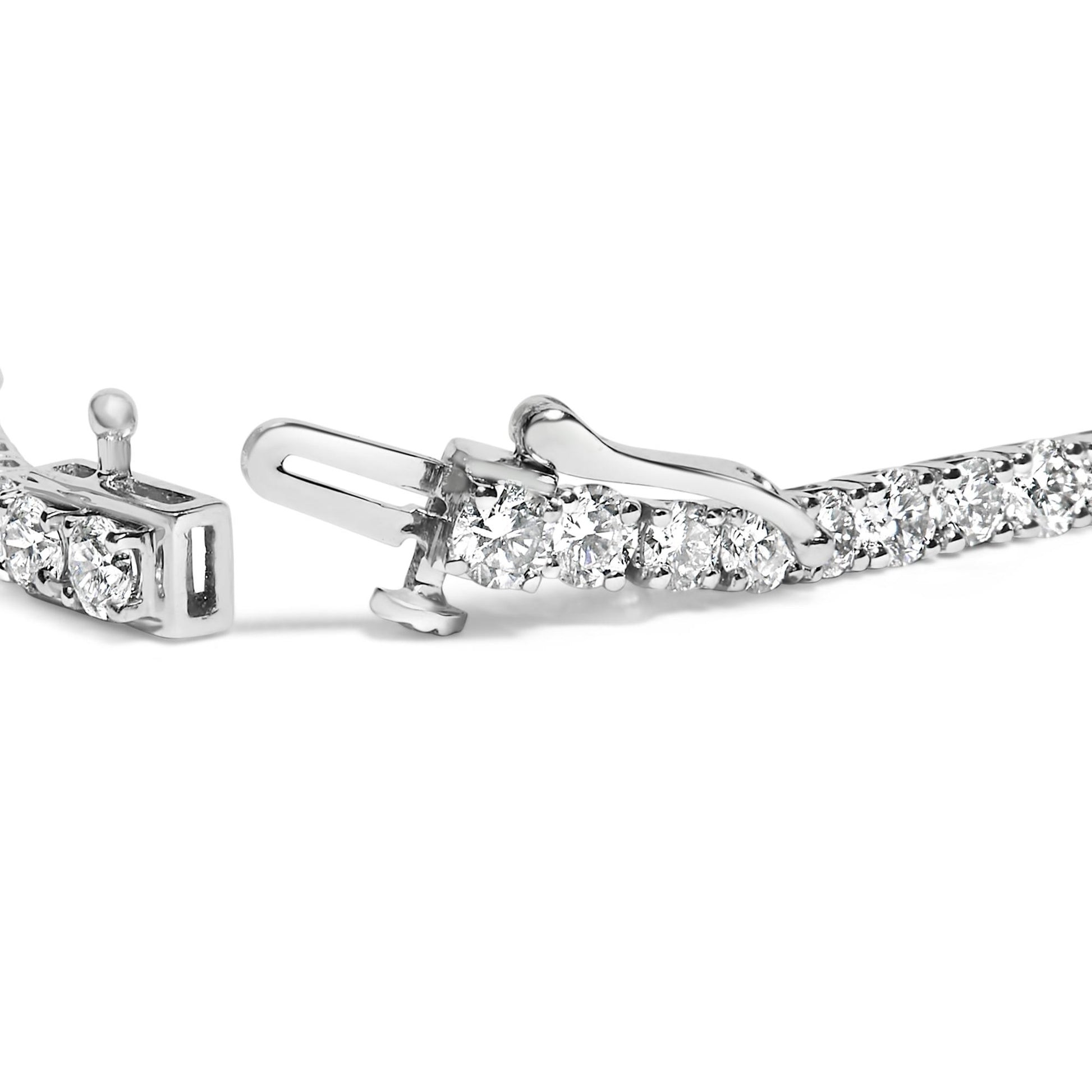 Close-up view of a white metal bracelet with round white gemstones in four-prong settings, showing the clasp mechanism.