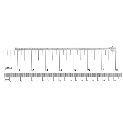 White metal bracelet with round white gemstones in four-prong settings, positioned flat on a ruler for size reference, top-down view.