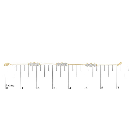 Yellow metal bracelet with sections of round white gemstones in prong settings, shown flat on a measurement scale, top-down angle.