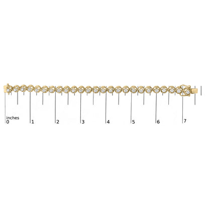 Close-up front view of a yellow metal bracelet with round white gemstones in prong settings, shown on a measurement scale.