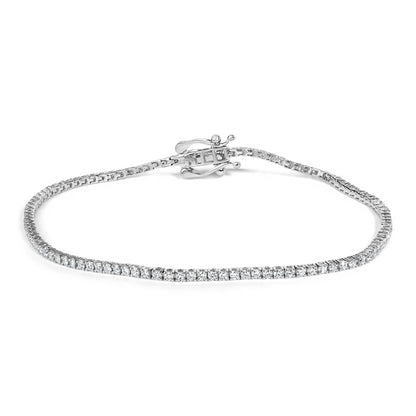 Close-up angle of a white metal tennis bracelet with round white gemstones in prong settings and a decorative clasp, shown on a white background.