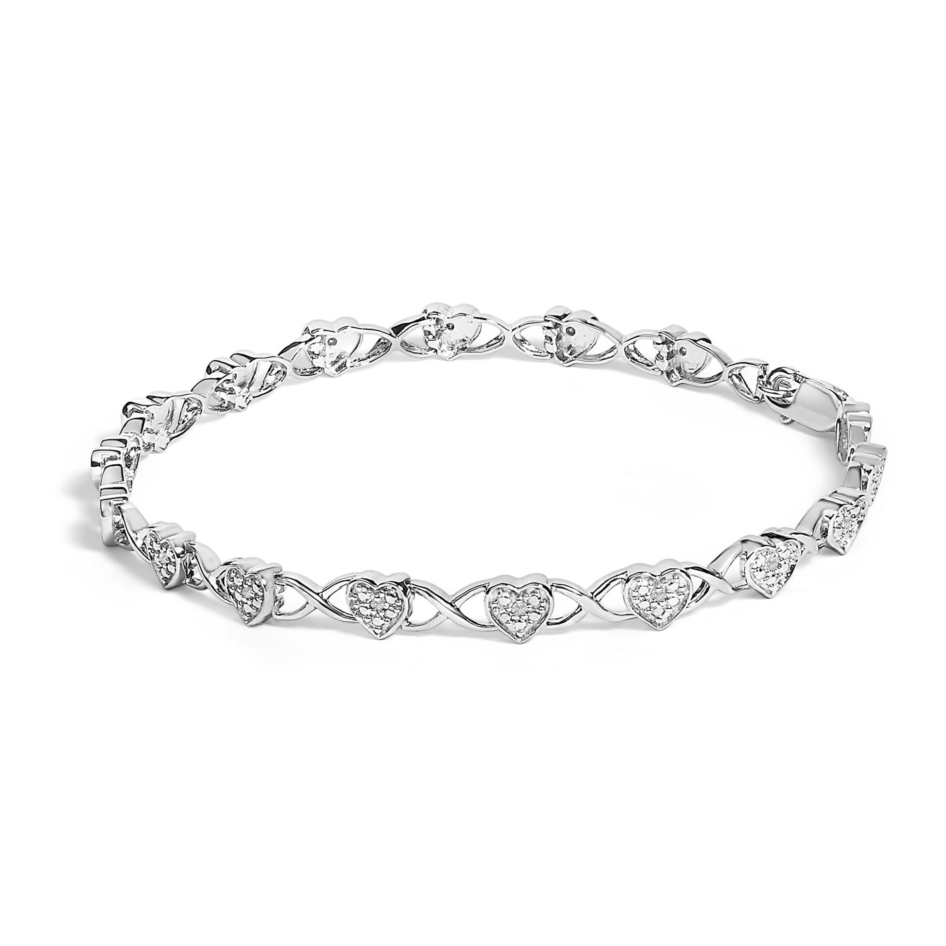 White metal bracelet with heart-shaped links featuring prong-set round white gemstones, shown at a slight angle on a white background.