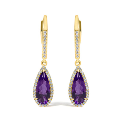 Close-up front view of yellow metal earrings featuring a vertical band decorated with small white gemstones in a micro-pave setting, and a dangling pear-shaped purple gemstone surrounded by small white gemstones.
