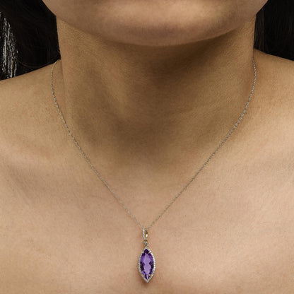 Yellow metal necklace with a marquise-shaped purple gemstone pendant surrounded by small round white gemstones in a micro-pave setting, shown worn on a model from a front angle.