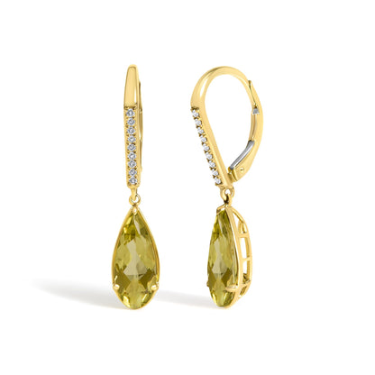 Close-up front angle of yellow metal earrings with round white gemstones in a micro-pave setting along the hoops and large lemon-colored pear-shaped gemstones dangling at the bottom.