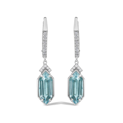Front view close-up of a pair of yellow metal drop earrings with white round gemstones in a micro-pave setting along the hooks, purple gemstones in prong settings, and elongated blue gemstones at the bottom.