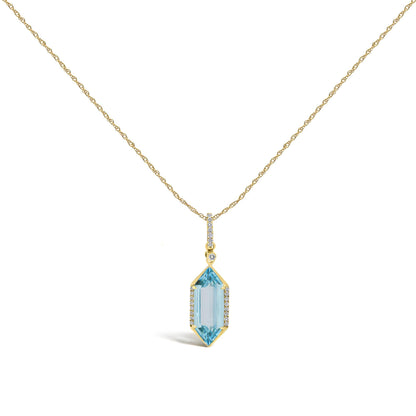 Close-up front angle of a yellow necklace with a vertical pendant. The pendant features a row of small white gemstones in a micro-pave setting and a larger elongated blue gemstone with a prong setting, also accented with small white gemstones. The necklace is shown on a white background.