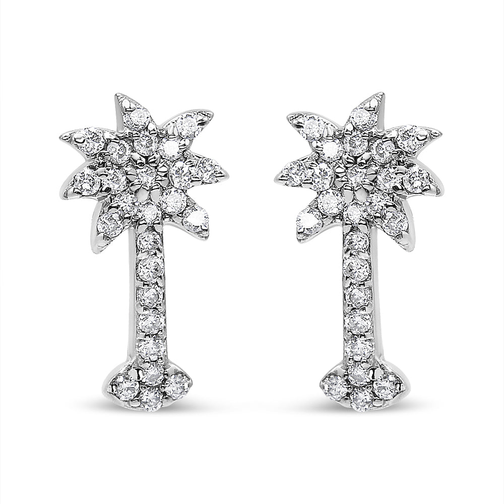Front view of a pair of white metal earrings shaped like palm trees, adorned with round brownish prong-set gemstones.