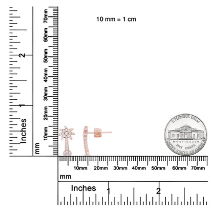 Front and side view of rose-colored metal earrings with white round gemstones in prong settings, displayed on a ruler and scale for size reference.