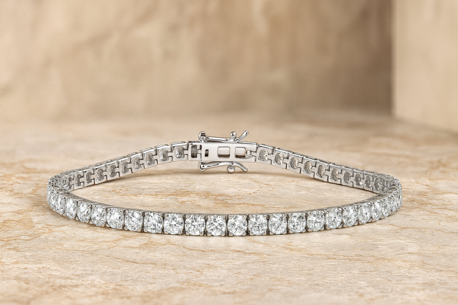 White metal tennis bracelet with two rows of round white gemstones in 4-prong settings, shown flat on a textured beige surface, front angle.