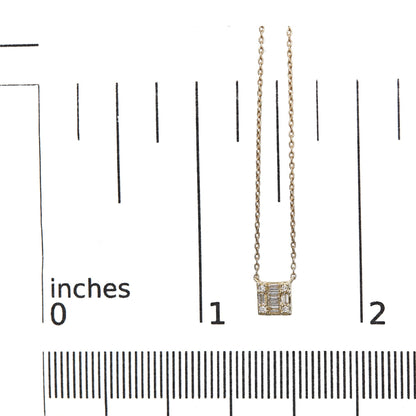 Close-up front view of a yellow metal necklace with a square pendant featuring white round and baguette-shaped gemstones in channel and prong settings, displayed on a ruler for size reference.