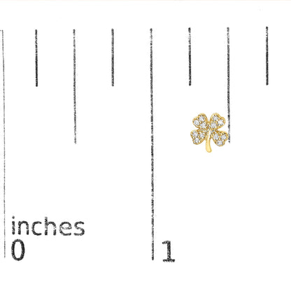 Yellow metal earring shaped like a four-leaf clover with round white gemstones in prong settings, shown on a scale from a front angle.