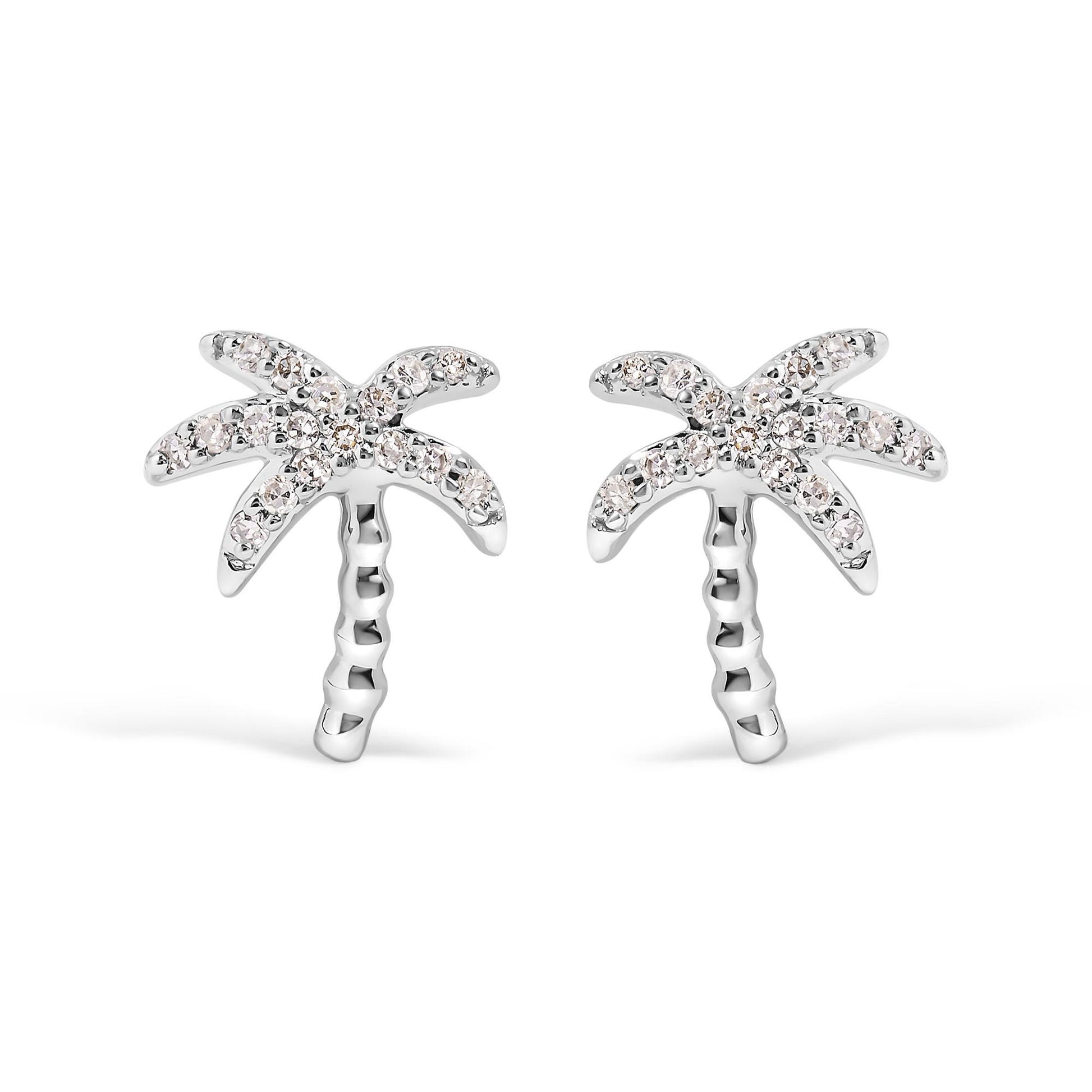 Front angle view of white metal earrings designed as palm trees with round white gemstones in pave setting on the leaves.