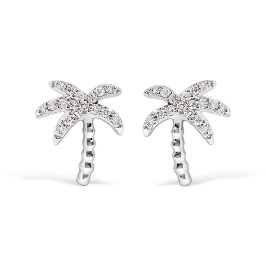 Front angle view of white metal earrings designed as palm trees with round white gemstones in pave setting on the leaves.