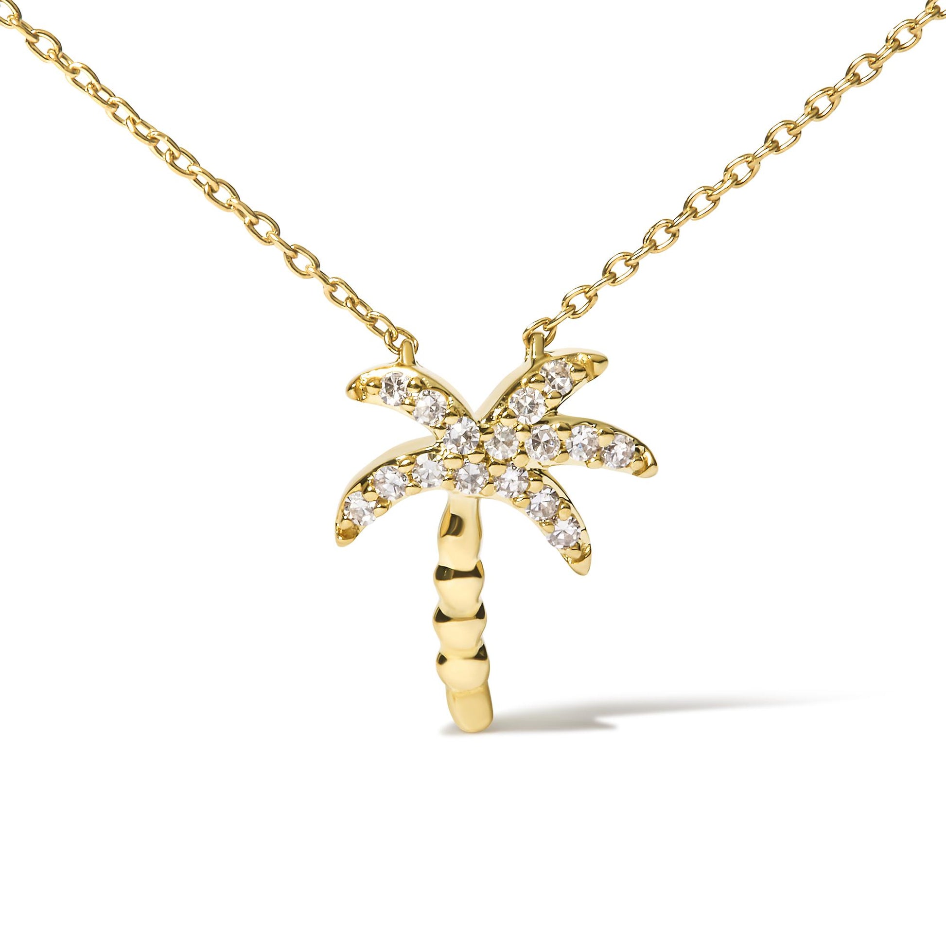 Yellow metal necklace with a palm tree-shaped pendant featuring round white gemstones in pave setting, shown from the front on a white background.