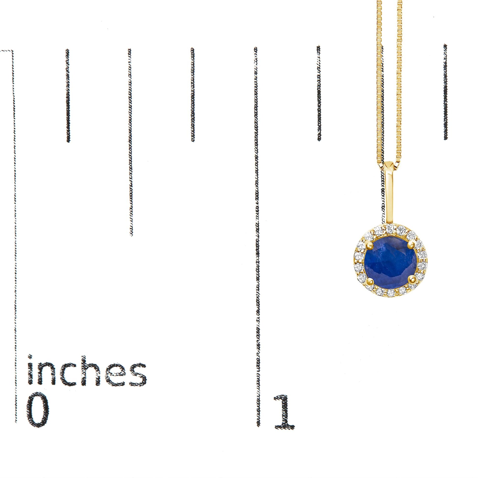 Yellow metal necklace with a round blue gemstone pendant surrounded by a halo of small white gemstones, shown on a scale with inch markings, front view.