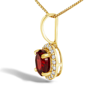 Yellow metal necklace pendant shown in a close-up side angle, featuring a round red gemstone in a four-prong setting surrounded by a halo of round white gemstones in a shared prong setting.